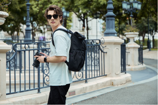 NayoSmart Urban U9 Roll‑top Backpack Black, man outdoor city lifestyle shot carrying rolltop backpack for commute travel photography