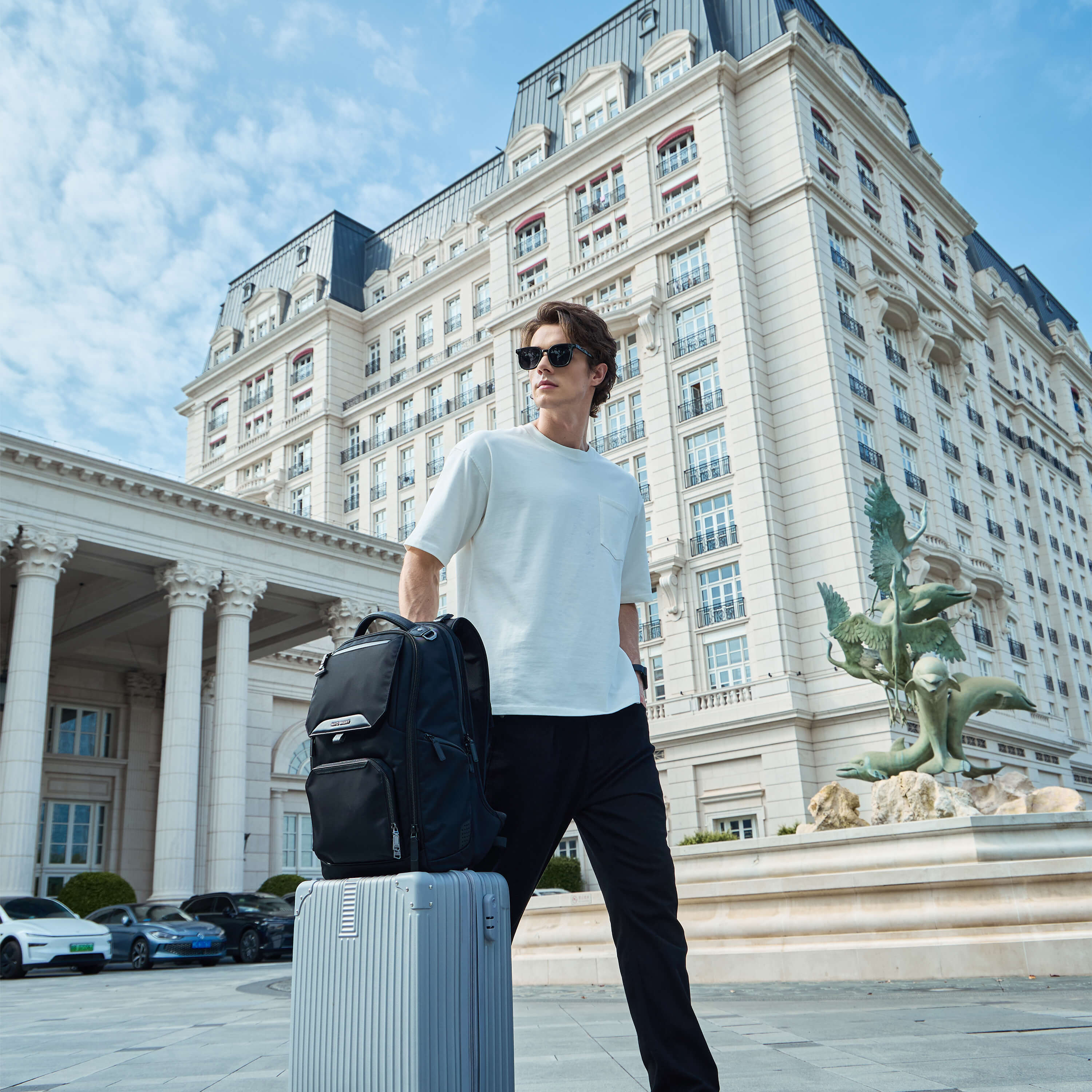Man carrying Nayo Smart Almighty A1 business travel backpack with rolling luggage outdoor travel scene