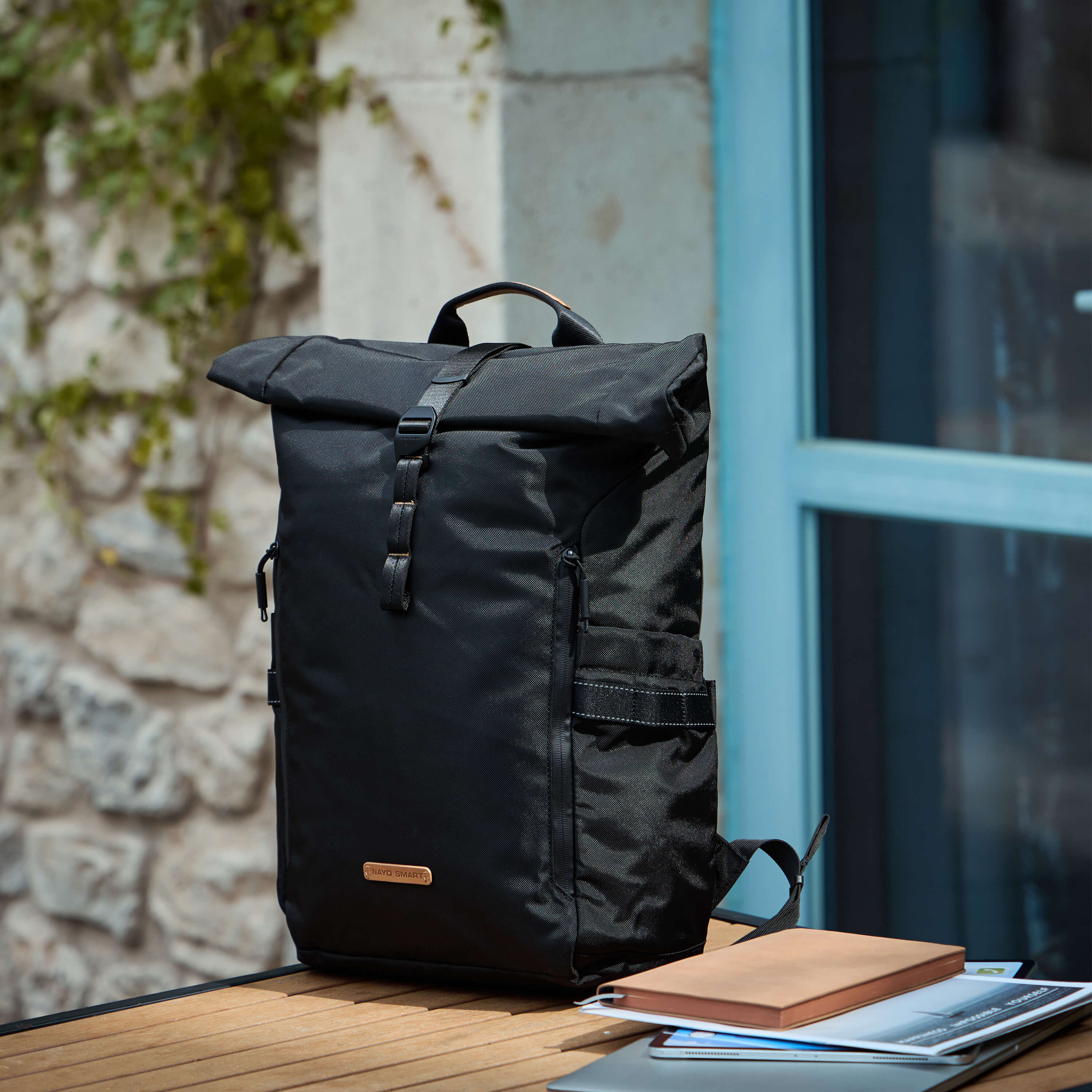 NayoSmart Urban U8 black roll-top backpack still-life scene by window with books, everyday carry lifestyle photography