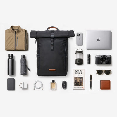 Flat-lay bundle of NayoSmart Urban U8 black roll-top backpack with laptop, clothes, water bottle, umbrella, camera and travel accessories