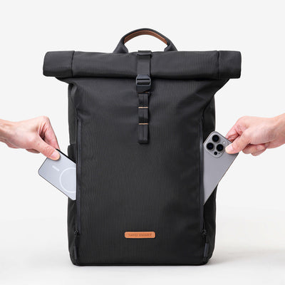 NayoSmart Urban U8 black roll‑top backpack, hands demonstrating side quick‑access pocket for phone and cards on white background