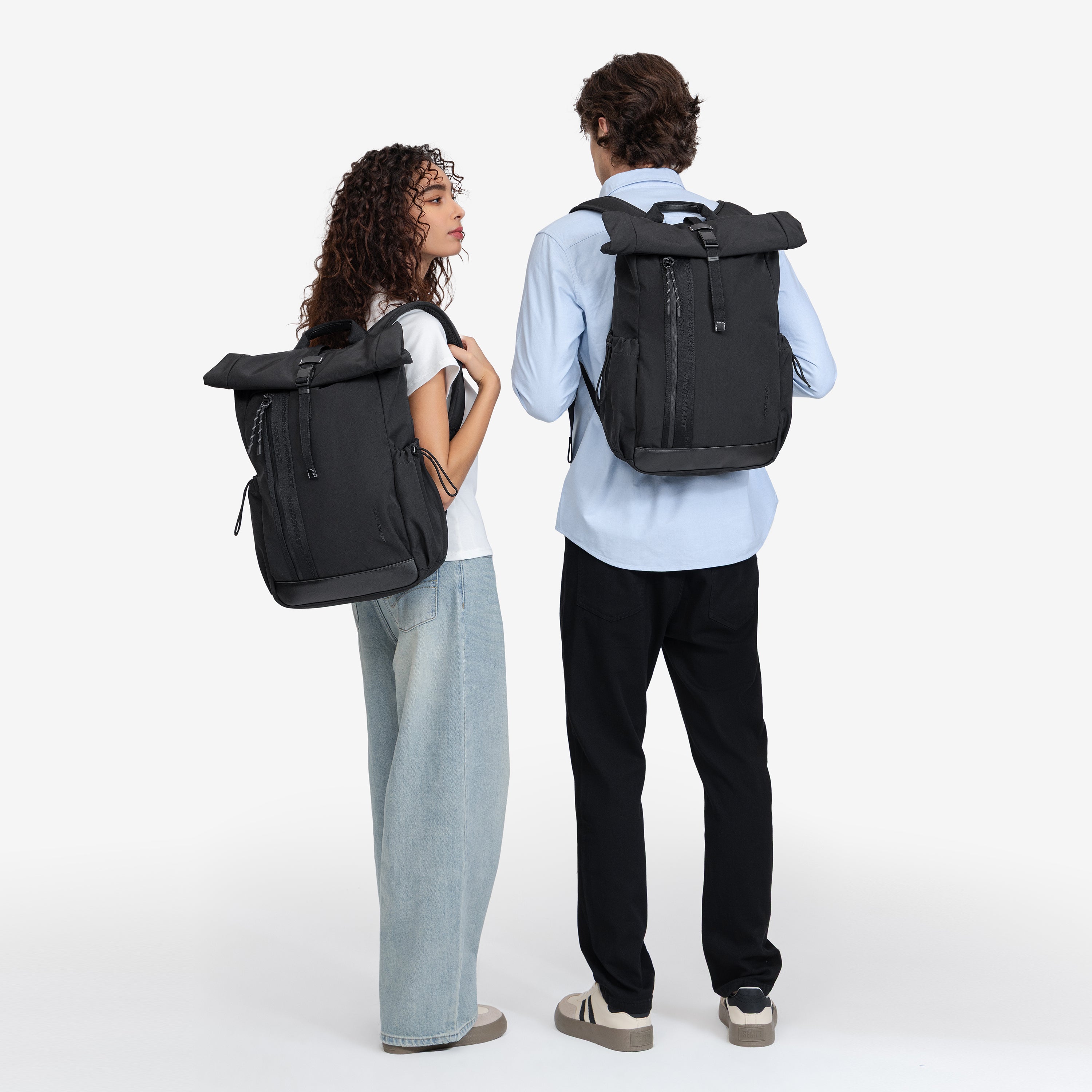 NayoSmart Urban U9 roll‑top backpack black couple back‑view studio shot, man and woman both wearing roll‑top commuter backpack