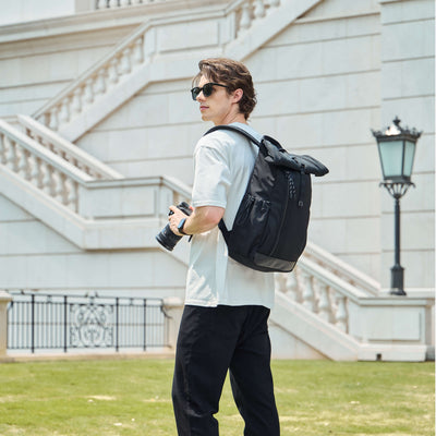 NayoSmart Urban U9 roll‑top backpack black male model outdoor city shot, photographer carrying camera and roll‑top backpack