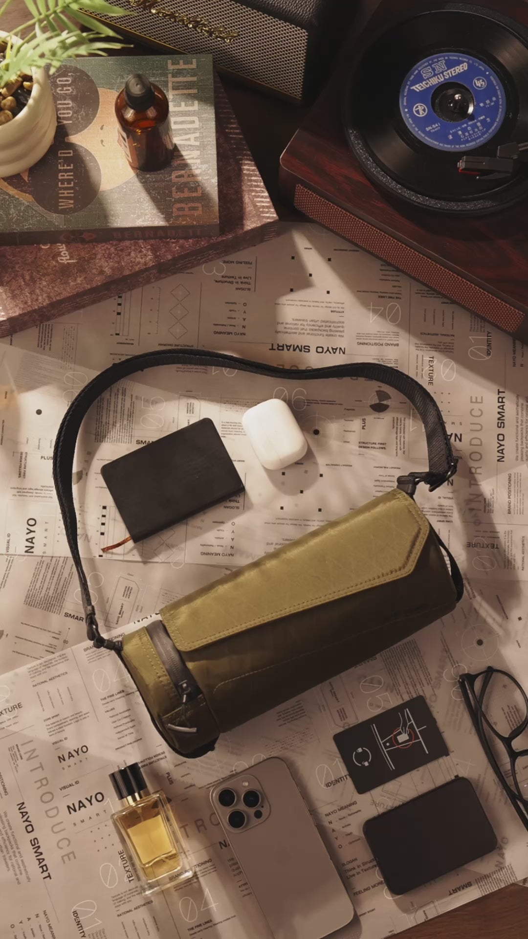 Olive Nayo Smart UL5 cylinder sling bag video thumbnail, vintage desk flat lay with EDC items#color_olive